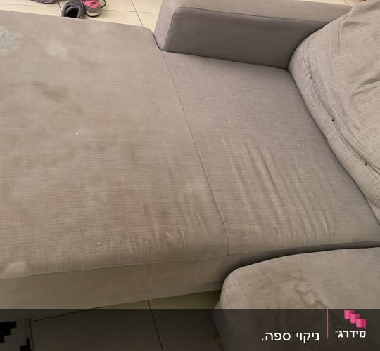 ספה אפורה עם כתמים על המושב